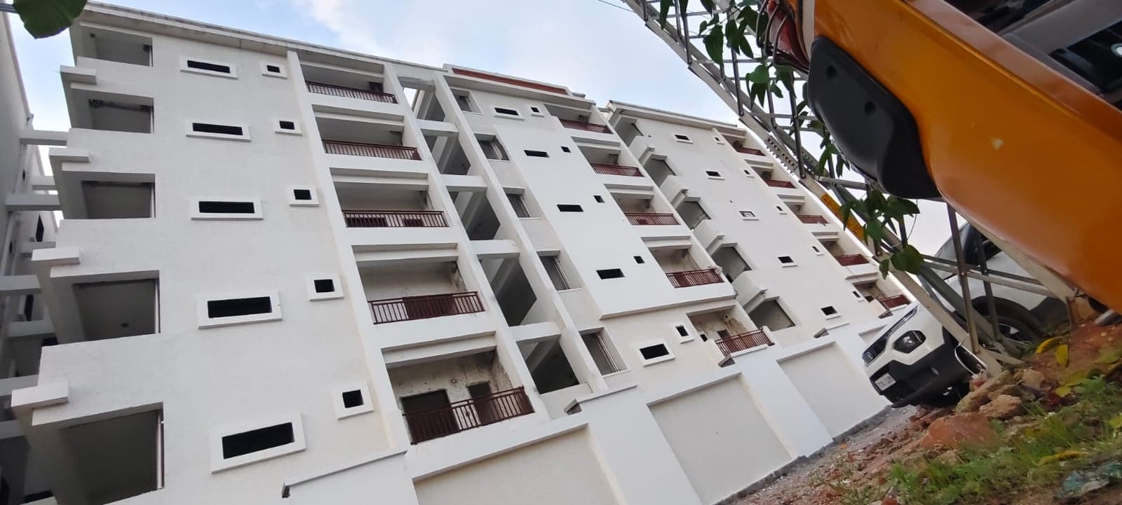 Multi-Wing Residency Complex with several apartment blocks featuring maroon balcony railings, in final finishing stage