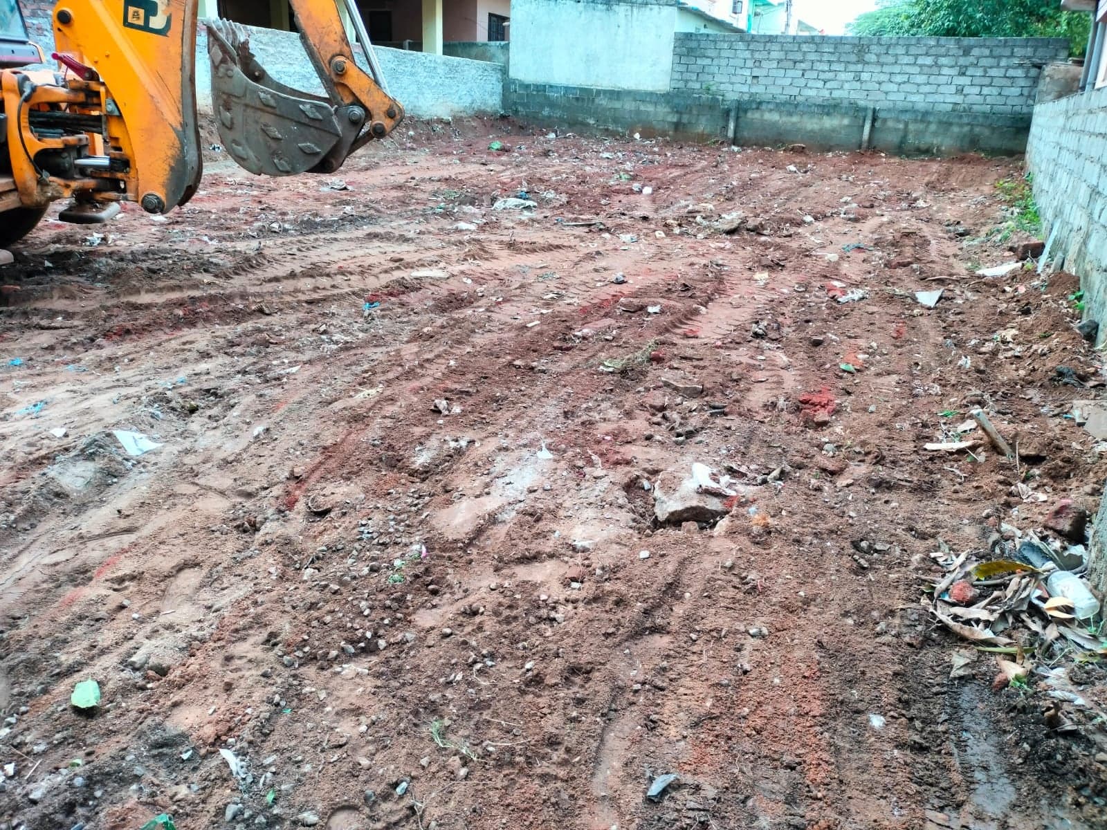 Excavator preparing a cleared site for foundation work, the first stage of construction