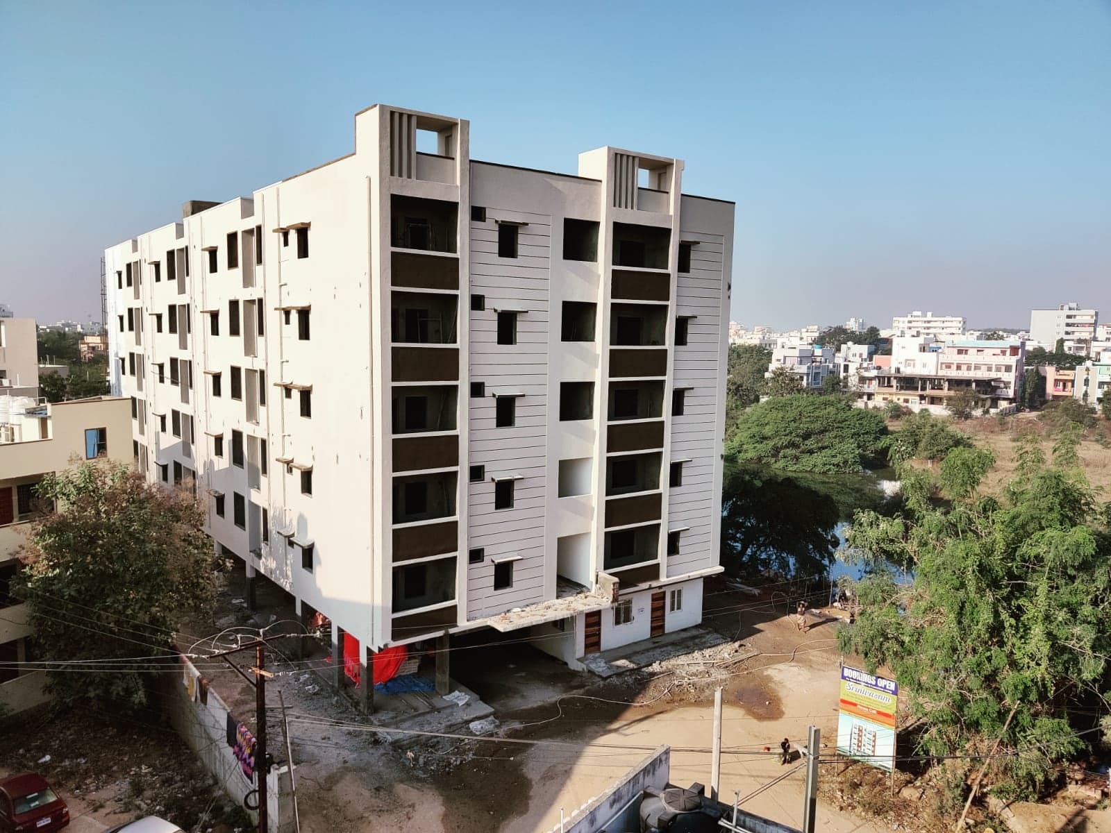 Srinivasam apartment building with structure and facade complete, signage installed, before final landscaping
